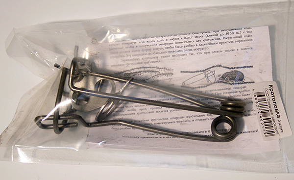 La photo montre un piège à taupe en fil métallique